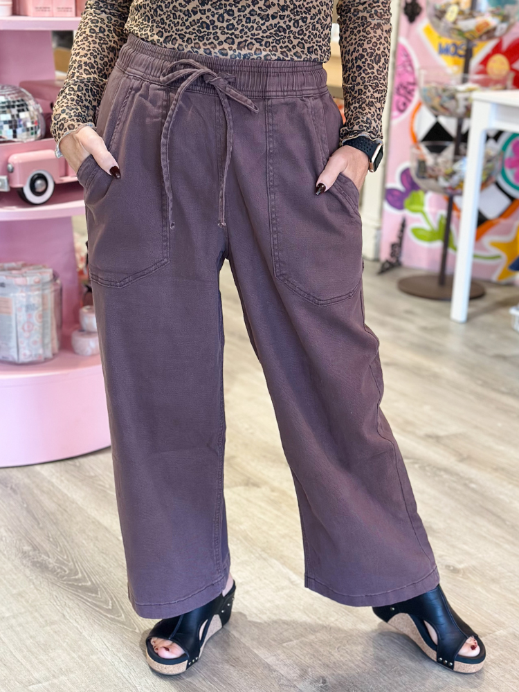 Person wearing purple pants with a leopard print top in a store setting