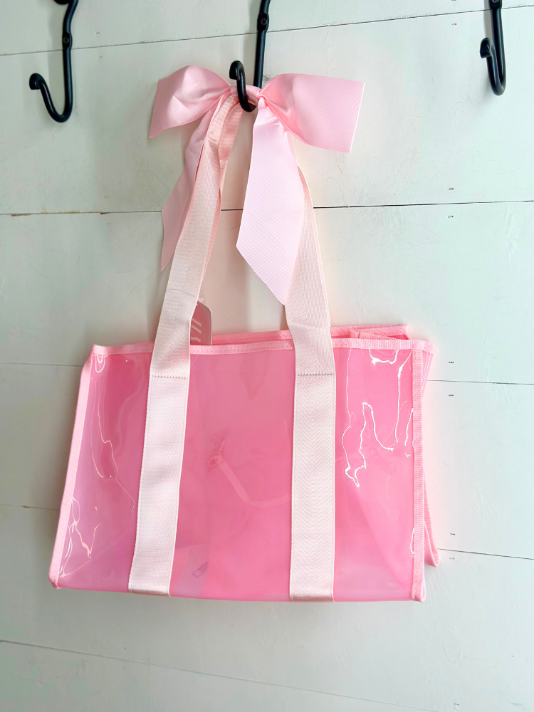 Pink and white striped bag with a bow hanging on a hook.